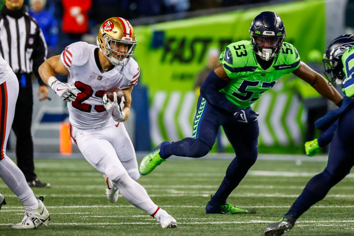 San Francisco 49ers running back Christian McCaffrey (23) rushes against the Seattle Seahawks during the second quarter at Lumen Field. Seattle Seahawks linebacker Boye Mafe (53) follows the play at right.